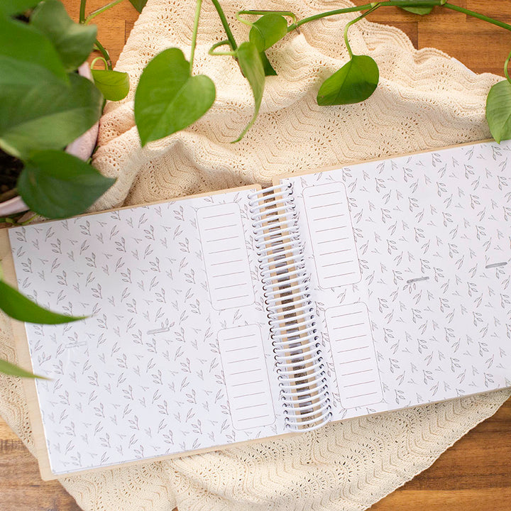 Top view of Hello Fern wooden photo album inner spread showing botanic design on photo sleeves with spaces for captions.