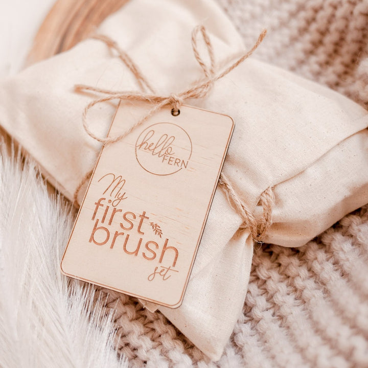 Closeup of beautiful wooden gift tag displayed on the cloth bag packaging for the Hello Fern My First Brush Sets.