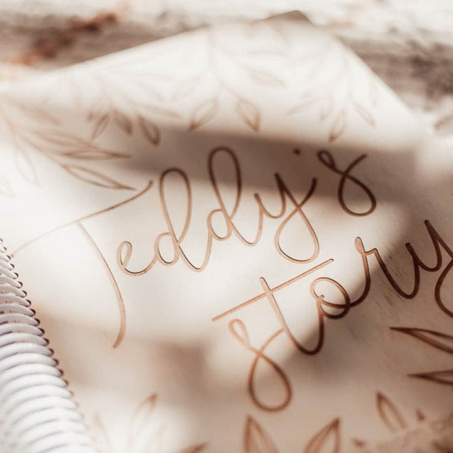 Closeup view with light and shadows from window on Hello Ferns' custom wooden baby memory book for Teddy.