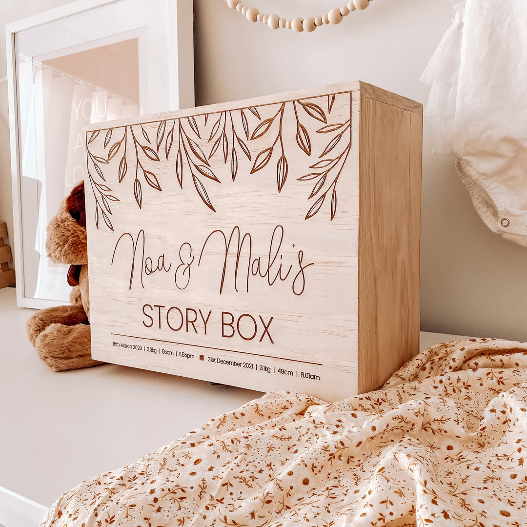 Large wooden box for storing keepsakes. Sitting on a shelf. Etched with 2 names and birth details.