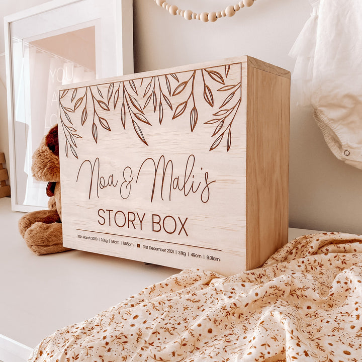 Large wooden box for storing keepsakes. Sitting on a shelf. Etched with 2 names and birth details.