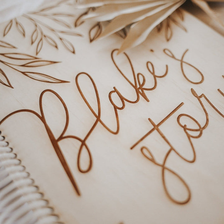 Closeup of etched custom wording, 'Blake's story' on Hello Fern custom wooden baby memory book cover.
