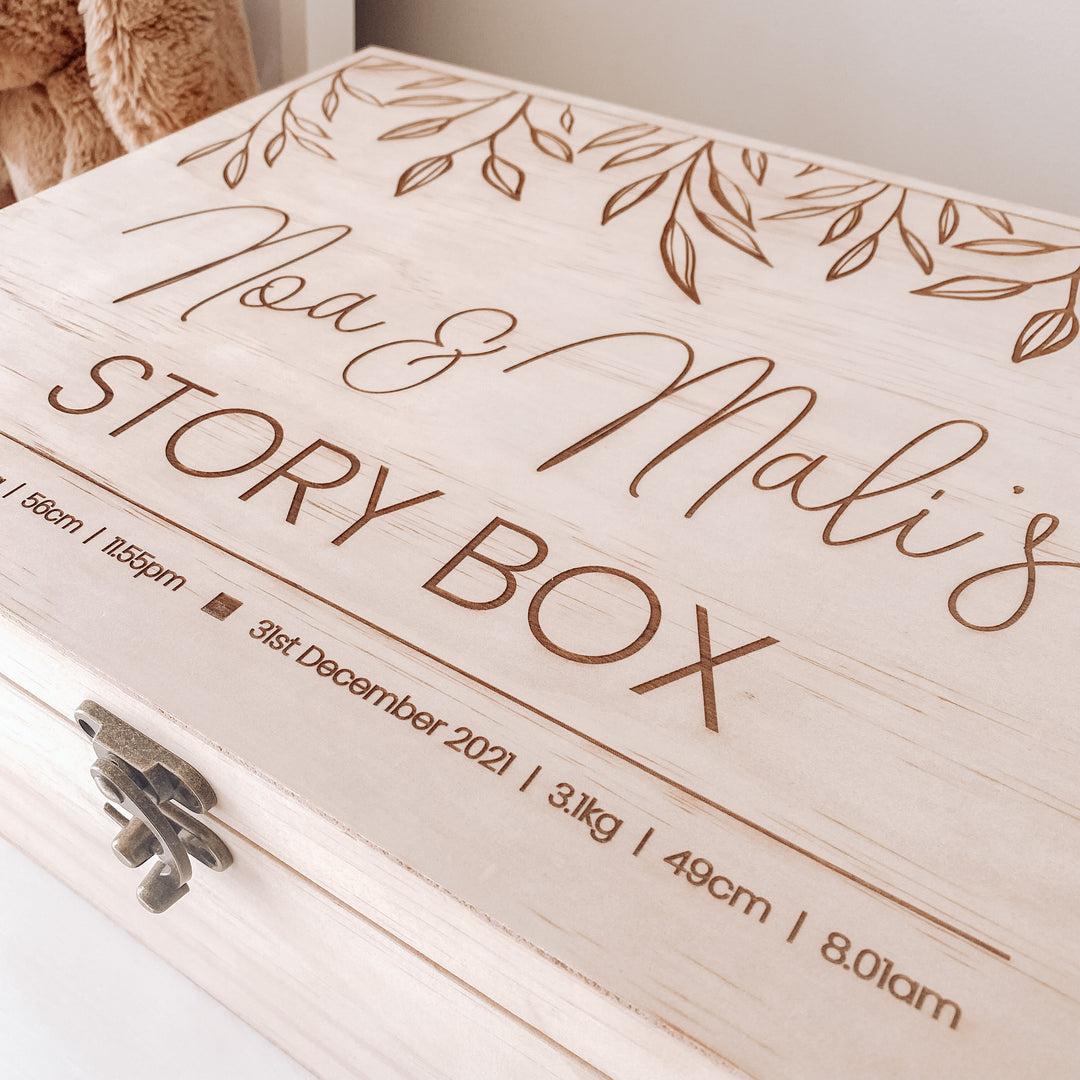 A large wooden keepsake box etched with names and birth details.