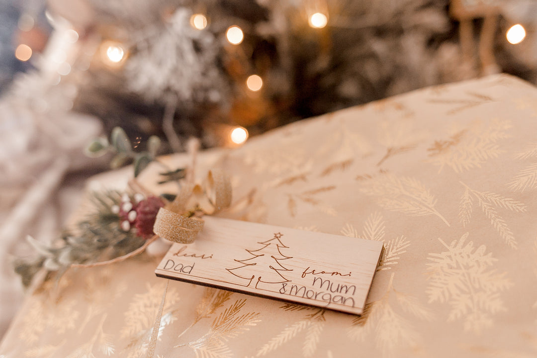 Closeup of non-custom Christmas gift tag with Christmas tree design etched into wood.