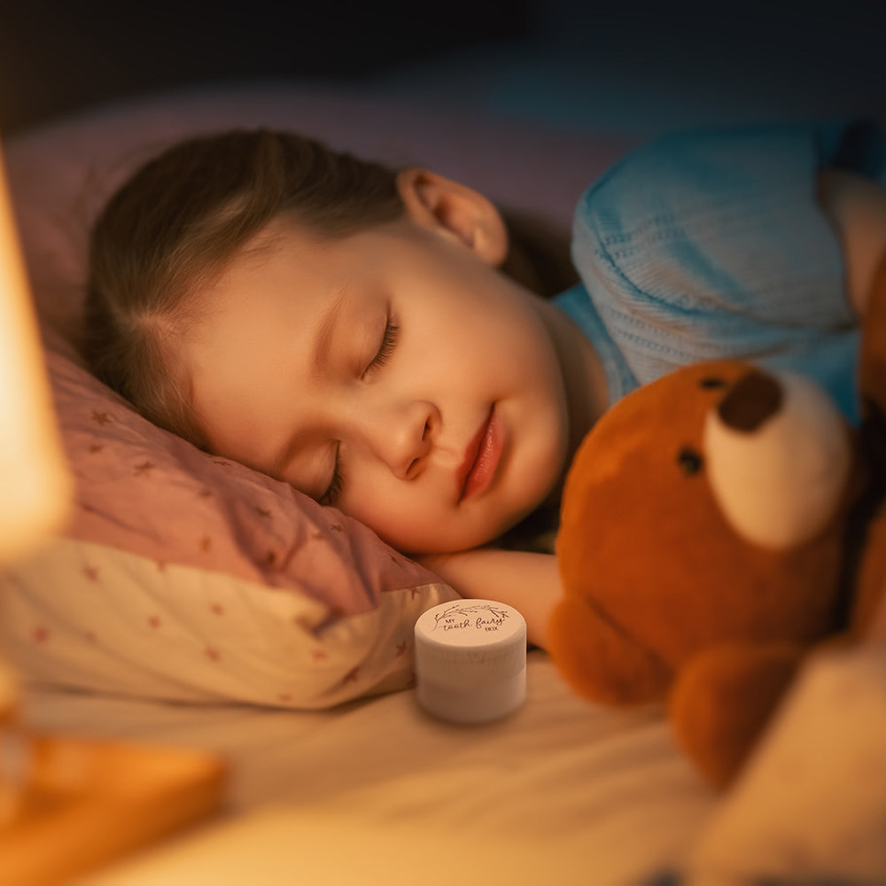 Child sleeping at night in her bed with Hello Fern wooden trinket tooth fairy box and teddy by her side