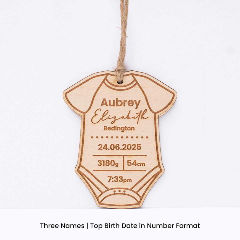 Hello Fern custom wooden baby onesie-shaped ornament with engraved baby birth details including first and last name on a white background.