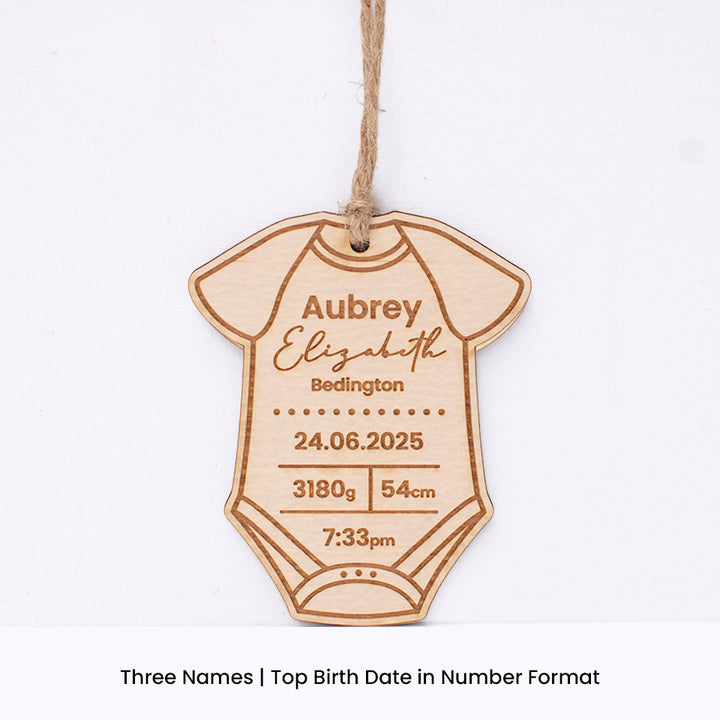 Hello Fern custom wooden baby onesie-shaped ornament with engraved baby birth details including first and last name on a white background.