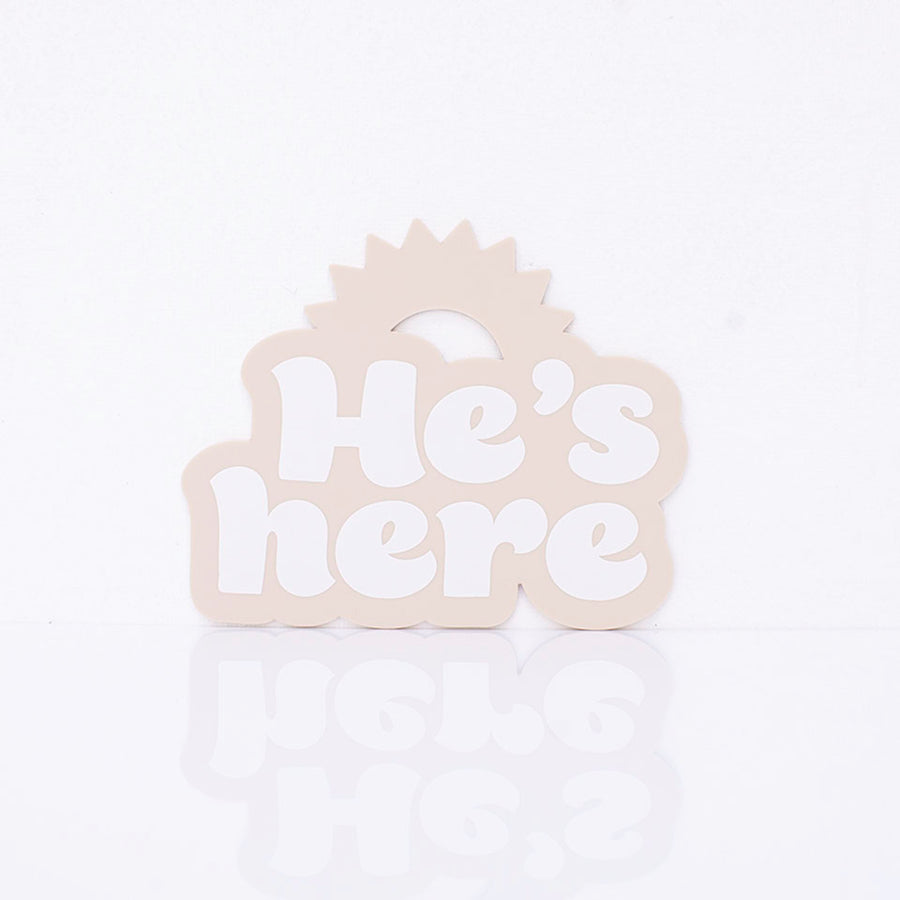 Hello Fern beige acrylic birth announcement shaped with a rising sun silhouette and around printed words "He's here".