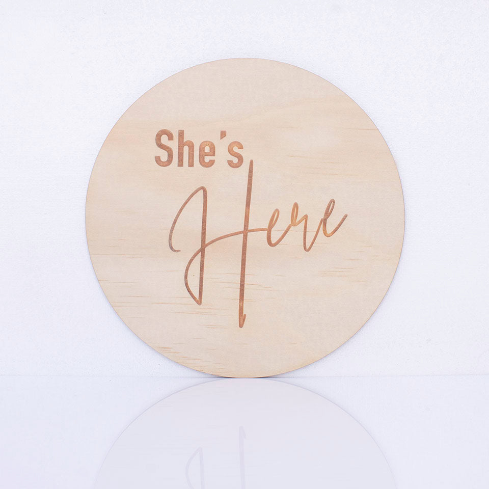 Hello Fern double-sided timber round birth announcement disc showing the "She's Here" side of plaque.