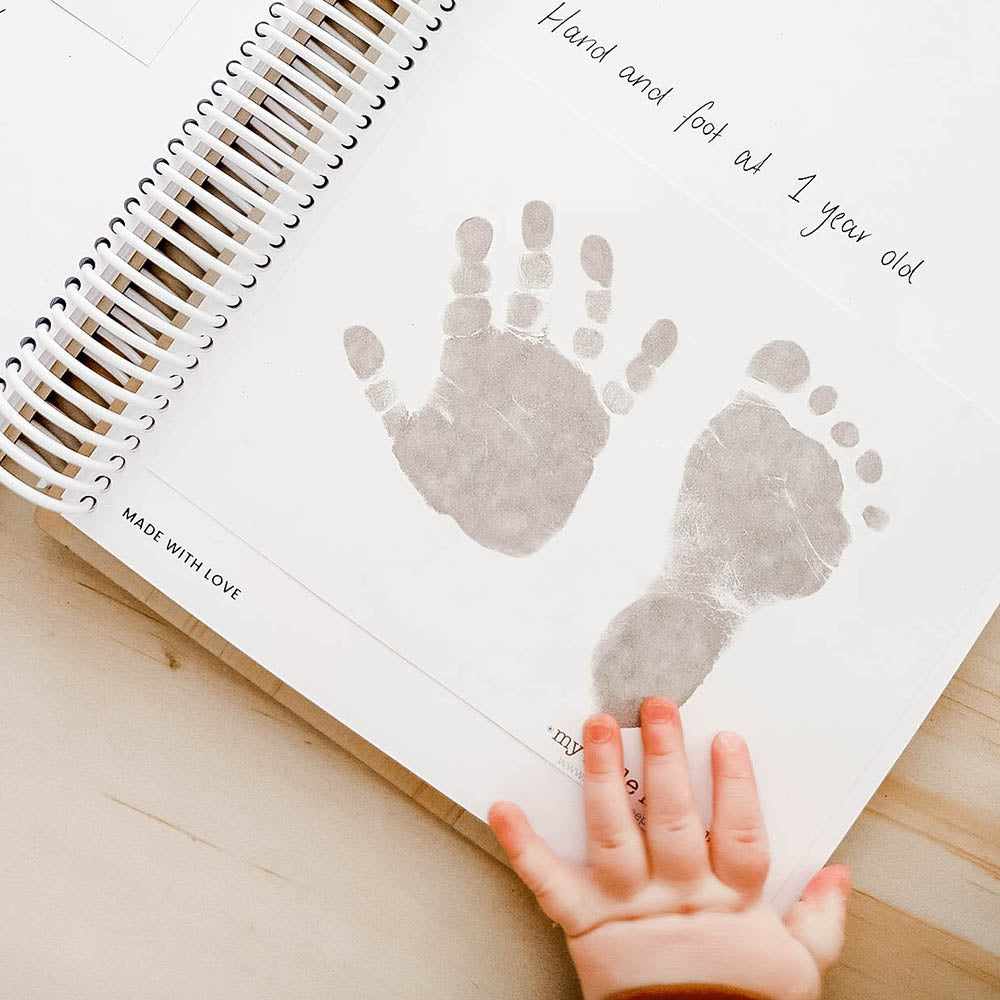 Hello Fern and My Little Keepsake Inkless Print Kit showing baby's hand and foot print in wooden baby book.