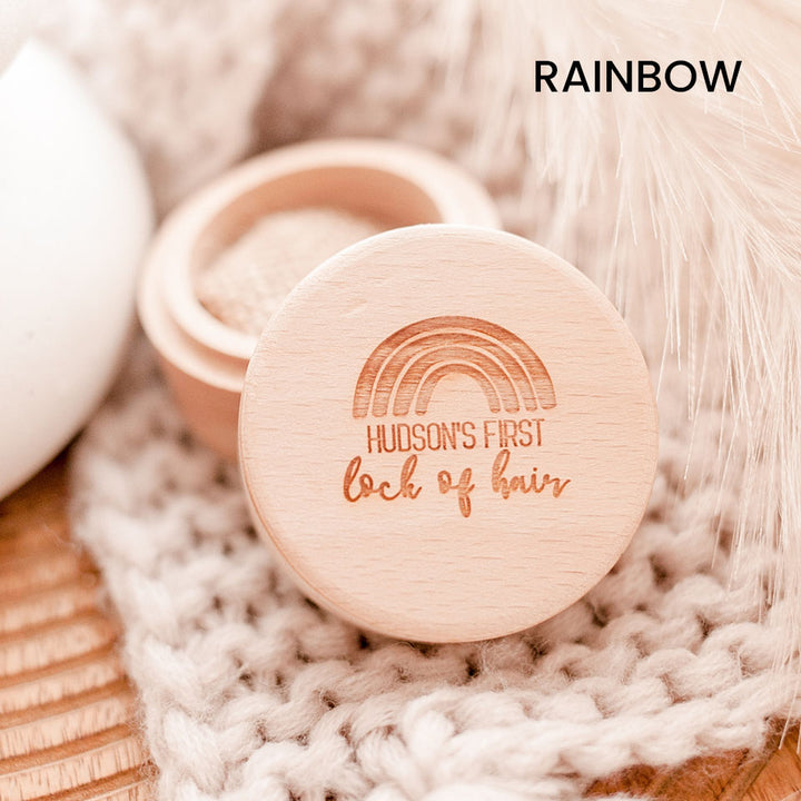 Closeup of Hello Fern baby's first lock of hair wooden trinket box in rainbow style, customised with child's name shown with lid open.
