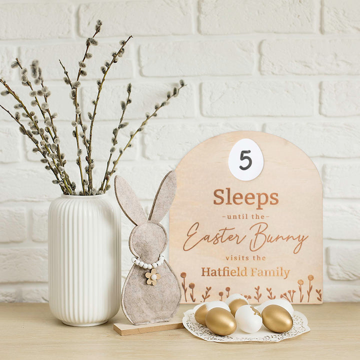 Hello Fern custom how many sleeps Easter countdown sign sitting against white brick wall with Easter decor.
