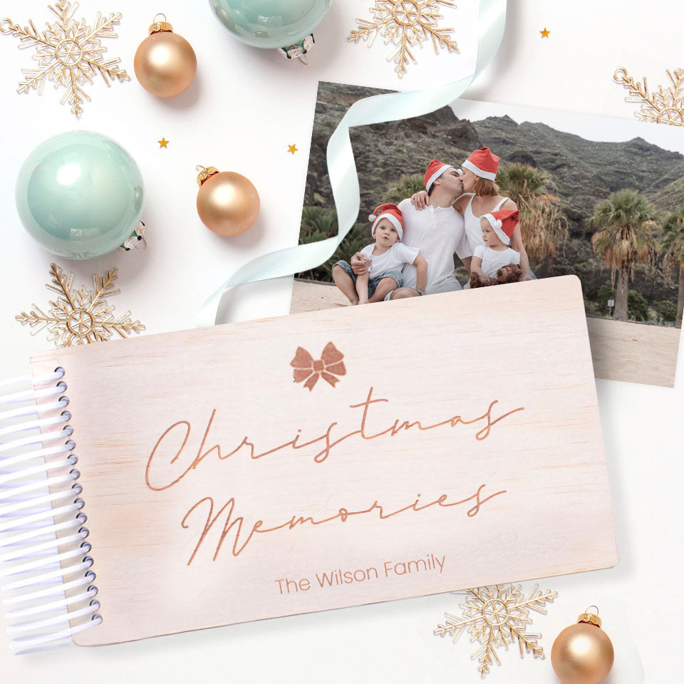 Christmas-themed personalised wooden photo album by Hello Fern with etched bow graphic, family photo and decorative ornaments on a white background