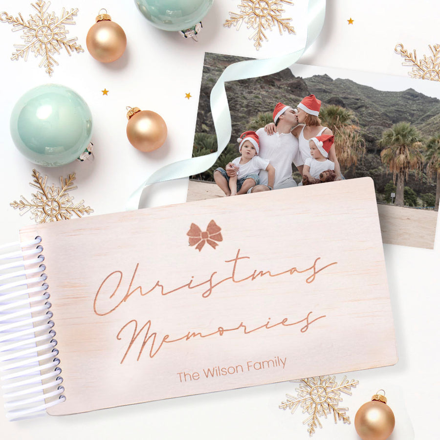 Christmas-themed personalised wooden photo album by Hello Fern with etched bow graphic, family photo and decorative ornaments on a white background