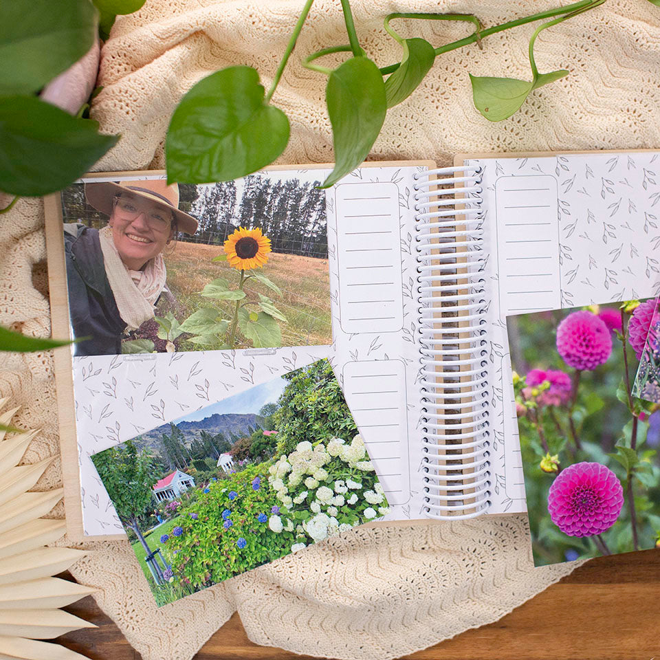 Top view of the inside of a Hello Fern wooden photo album showing beautiful flower photos from a family holiday, and spaces for hand-written captions.