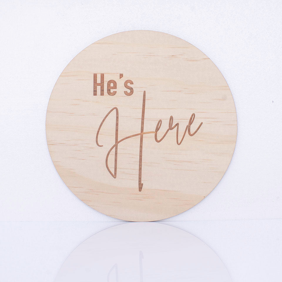 Hello Fern double-sided timber round birth announcement disc showing the "He's Here" side of plaque.