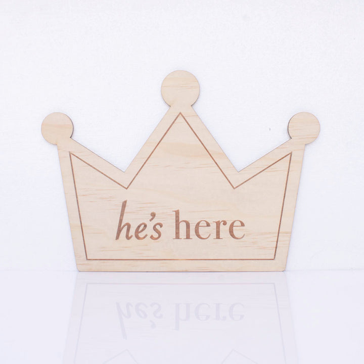 Hello Fern double-sided wooden birth announcement plaque in the shape of a crown displaying the side with the words "he's here".