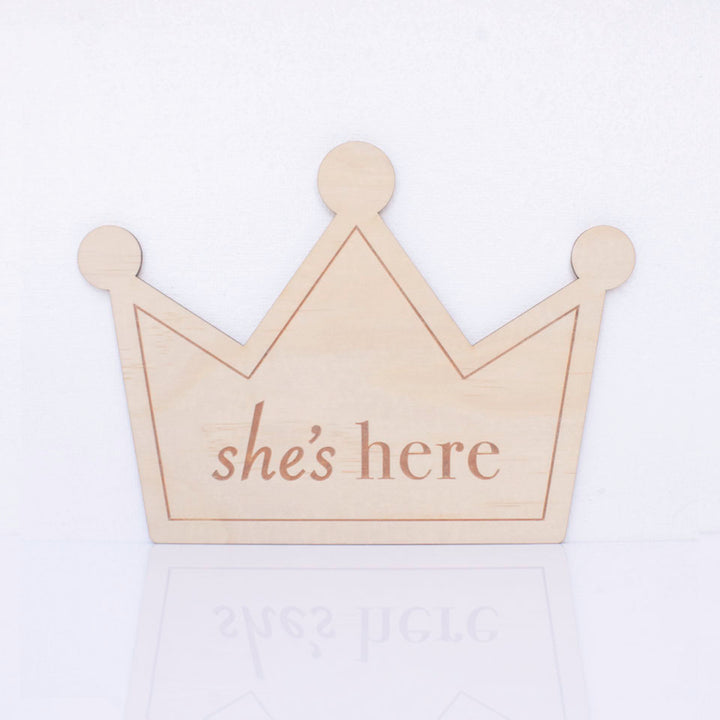 Hello Fern double-sided wooden birth announcement plaque in the shape of a crown displaying the side with the words "she's here".