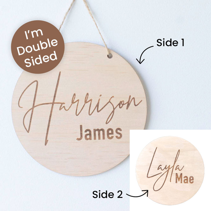 Personalized round wooden hanging plaque shown from two sides on a light wall. The main view shows the front with the words “Harrison James” engraved in brown, and a brown badge says “I’m Double Sided.