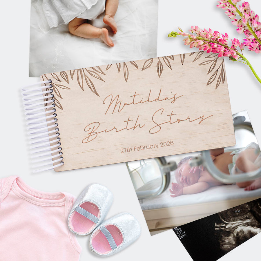 Hello Fern personalised mini wooden baby birth-themed photo album titled 'Matilda's Birth Story' with baby shoes and photos on a white surface.