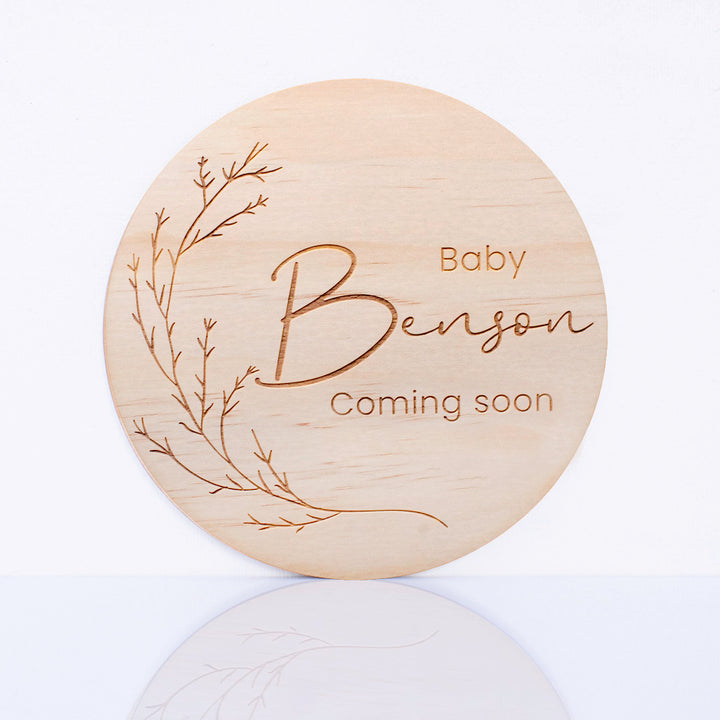 Hello Fern personalised round wooden plaque with 'Baby Benson Coming soon' text on a white background.