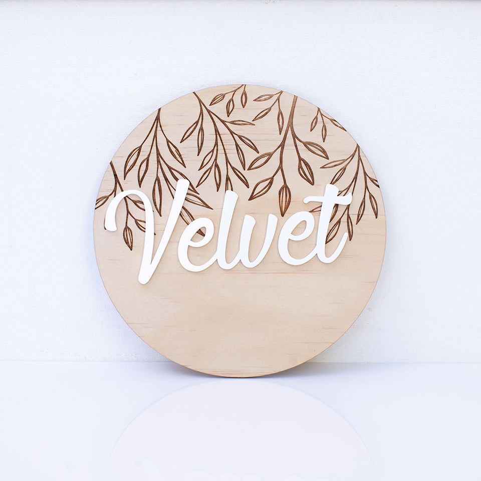 Hello Fern wooden and acrylic 3D name plaque with the name 'Velvet' in white acrylic, adhered to an etched wooden disc against a white background.