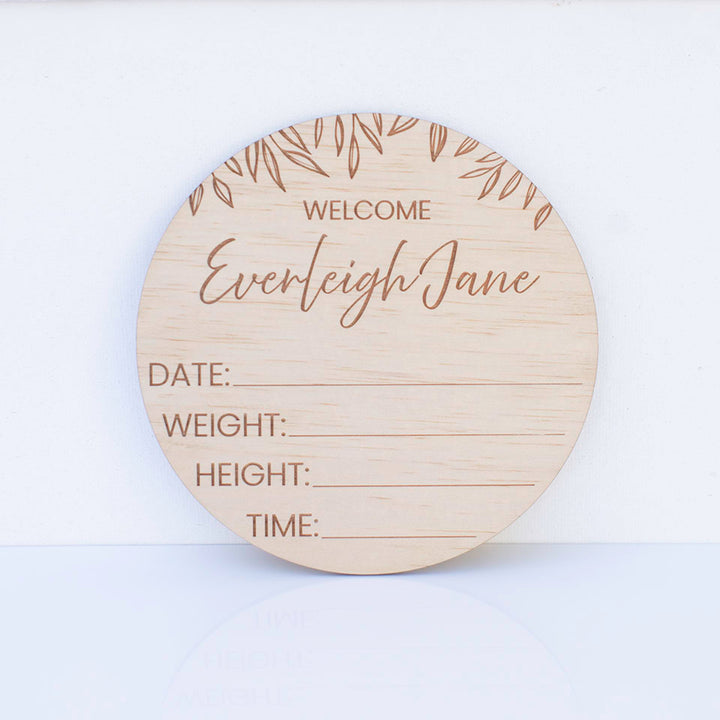 Hello Fern custom wooden birth announcement disc on white background.