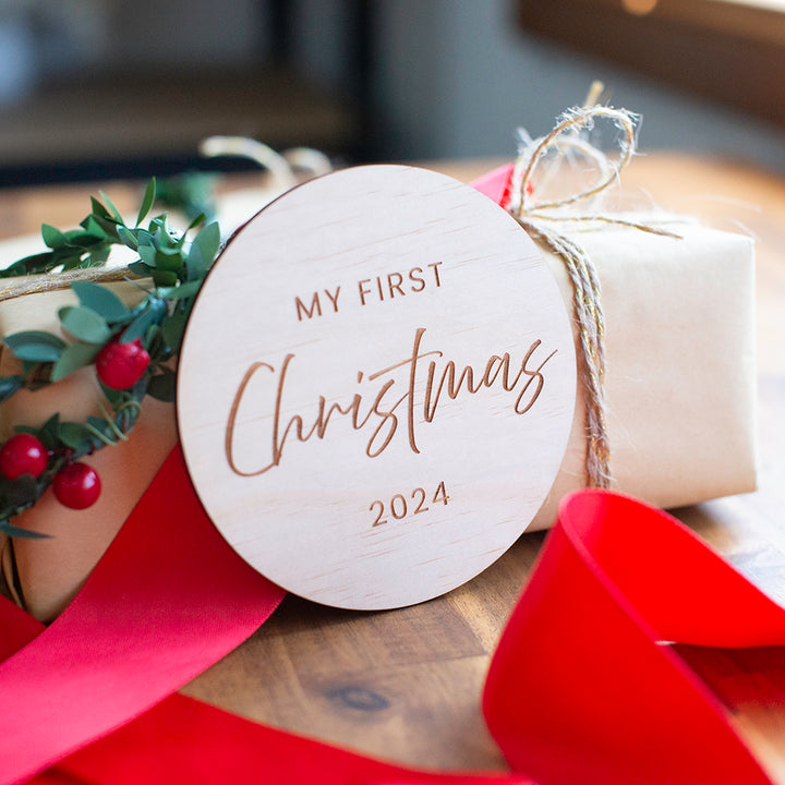 Closeup of Hello Fern "My first Christmas" non-custom wooden keepsake plaque with gift and ribbon.