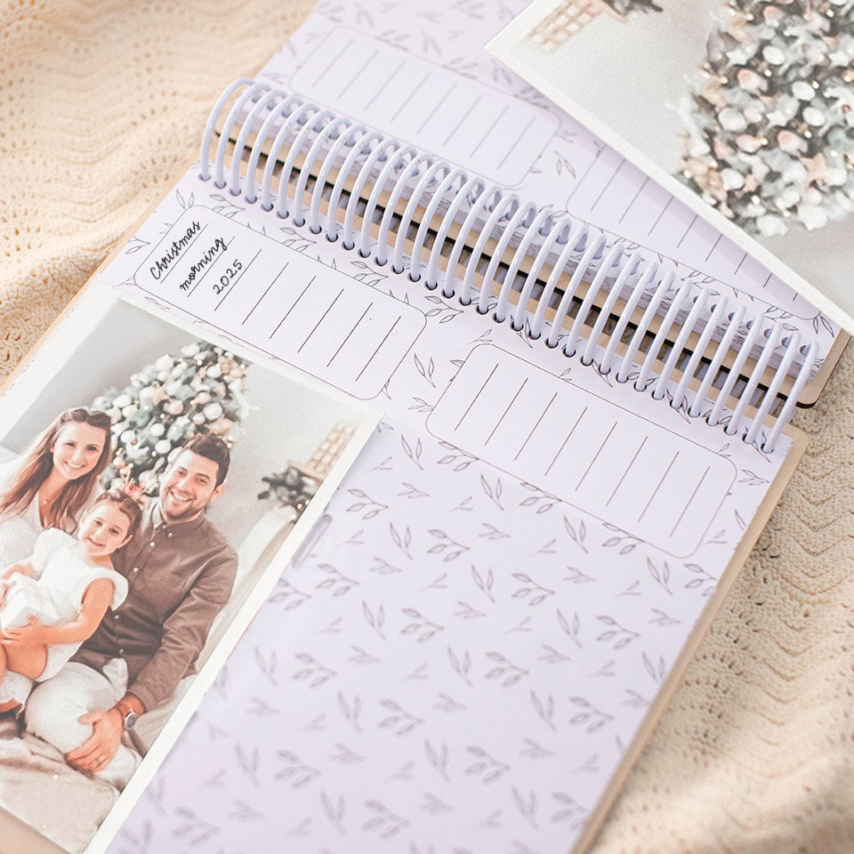 Inside view of Hello Fern custom wooden Christmas photo album showing 4x6 famly photos in front of the Christmas tree and hand-written picture captions.