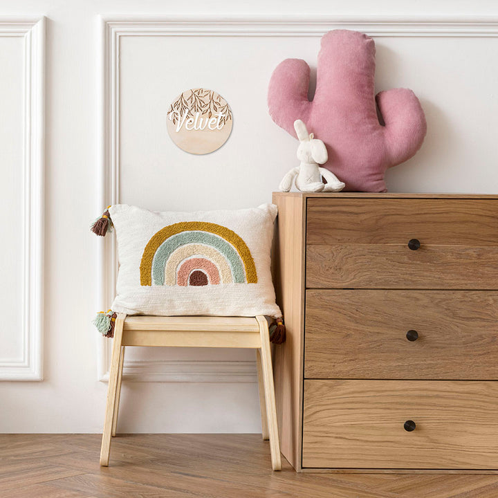 Hello Fern small wooden and acrylic 3D name plaque shown hanging on wall in child's bedroom with rainbow cushion, dresser, chair, and stuffed toys.