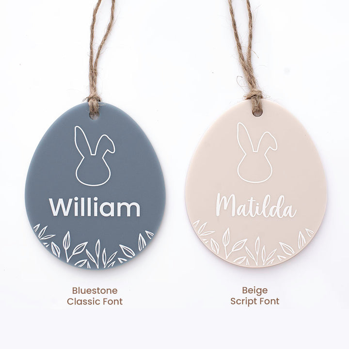 Set of two Hello Fern acrylic egg-shaped Easter basket name tags with font and colour options isolated on white background.