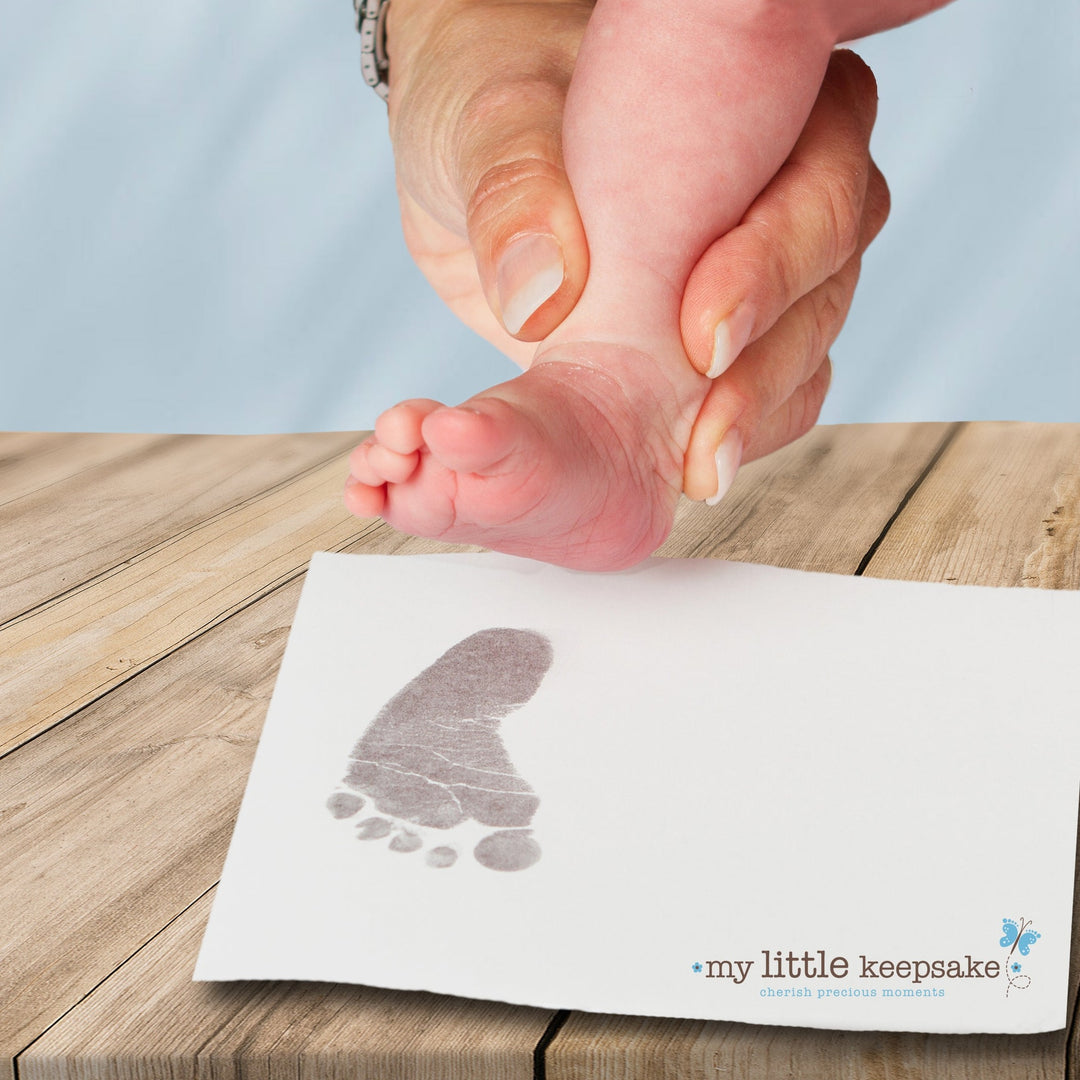 Inkless print kit showing baby's foot print using grey ink.