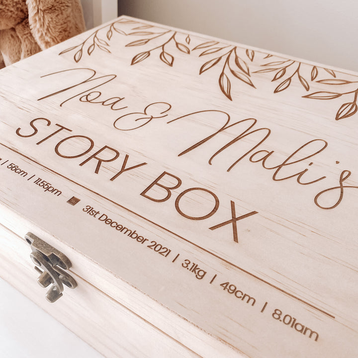 A large wooden keepsake box etched with names and birth details. 
